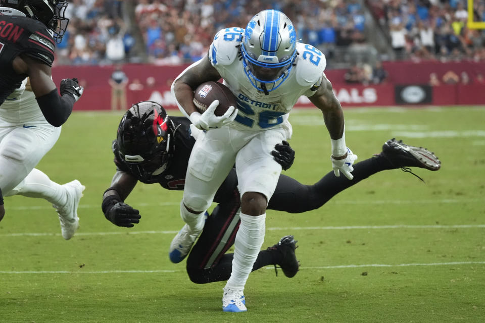 Detroit Lions running back Jahmyr Gibbs (26) scores a touchdown on a run after receiving a lateral from wide receiver Amon-Ra St. Brown during the first half of an NFL football game against the Arizona Cardinals Sunday, Sept. 22, 2024, in Glendale, Ariz. (AP Photo/Ross D. Franklin)