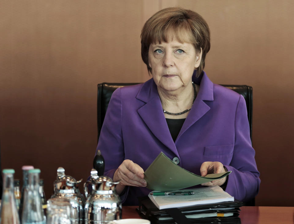 German Chancellor Angela Merkel works on her documents after arriving for the weekly cabinet meeting at the chancellery in Berlin, Germany, Wednesday, April 2, 2014. (AP Photo/Markus Schreiber)