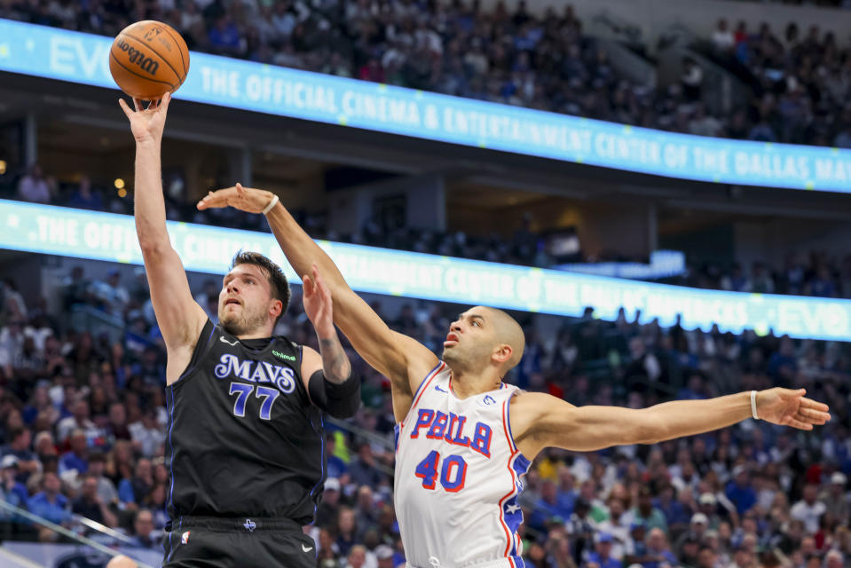 Dallas Mavericks guard Luka Doncic (77) shoots as Philadelphia 76ers forward Nicolas Batum (40) defends during the first half of an NBA basketball game Sunday, March 3, 2024, in Dallas. (AP Photo/Gareth Patterson)