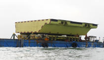 A yellow barrier, part of a plan to protect the city of Venice from flooding, floats on a barge, in Venice, Italy, Friday, Nov. 29, 2019. Central to the plan to protect Venice, some, or all, of the 78 barriers will one day be raised when the sea rises more than 110 centimeters to prevent damaging high tides from pushing into the lagoon city, a UNESCO heritage site built picturesquely but somewhat precariously among more than 120 islands. (AP Photo/Antonio Calanni)