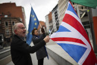 Two people holding EU, Ireland and Union shout anti-Brexit slogans during a meeting between UK Brexit secretary Stephen Barclay and European Union chief Brexit negotiator Michel Barnier at the European Commission headquarters in Brussels, Friday, Oct. 11, 2019. The European Union said Friday that talks with the United Kingdom to find an amicable divorce with the United Kingdom are back on track, despite huge challenges and a tight end-of-month deadlime looming large. (AP Photo/Francisco Seco)