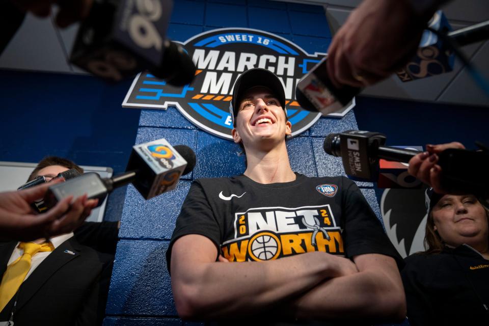Iowa's Caitlin Clark (22) speaks with reporters in the locker room after beating LSU in the Elite Eight round of the NCAA Women's Basketball Tournament on Monday.