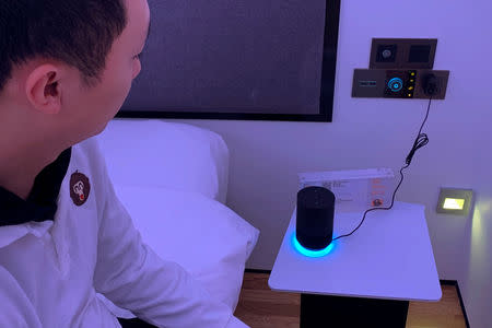 A staff member sits next to smart speaker Tmall Genie during a demonstration to the media inside a room of Alibaba Group's futuristic FlyZoo hotel in Hangzhou, Zhejiang province, China January 22, 2019. REUTERS/Xihao Jiang