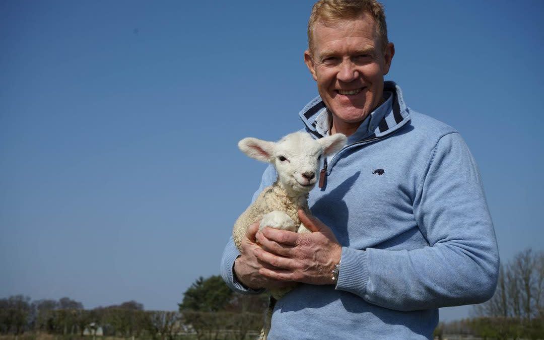 Adam Henson with a lamb on the farm