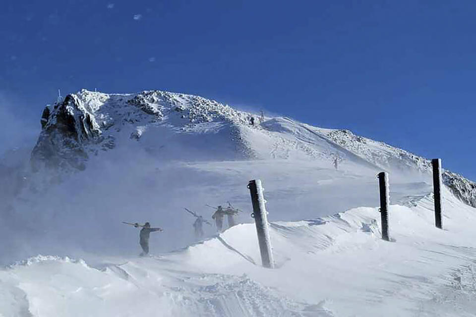 ADDS NAME OF SKI RESORT - Skiers climb to the top of a mountain near Palisades Tahoe, a California ski resort near Lake Tahoe, on Thursday, Jan. 11, 2024, in Calif. After closing down every lift and trail in the avalanche's aftermath, Palisades Tahoe reopened many runs on Thursday. But its iconic KT-22 lift, which serves the area of mostly expert runs where the slide occurred, remained closed while crews worked to clear a road to enable snowcats and snowmobiles to enter and clean up. (Mark Sponsler via AP)