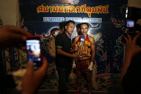 A fighter in interviewed after his win during the closing Thai boxing, or "Muay Thai", fight night of the legendary Lumpinee stadium, one of Bangkok's oldest boxing venues which is being demolished after 57 years, February 7, 2014. REUTERS/Damir Sagolj