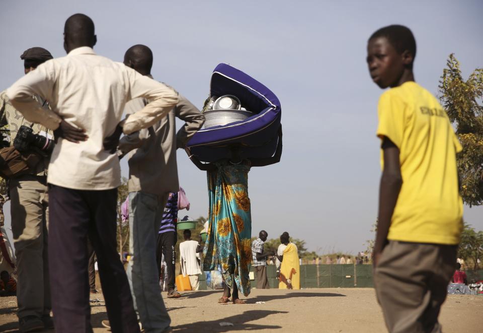 An internally displaced woman carries her belongings inside a UNMIS compound in Juba