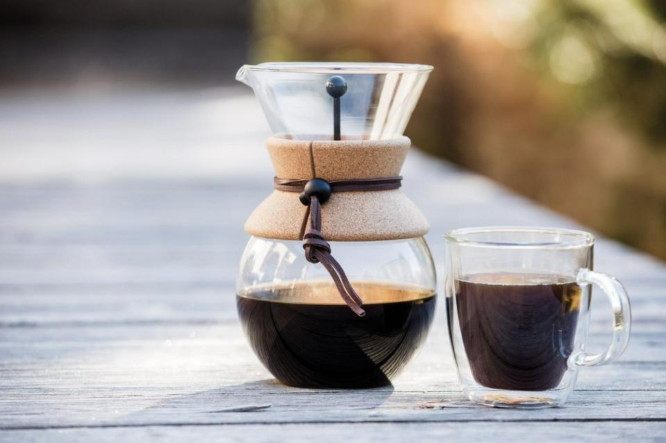 A pour over coffee dripper and a cup of coffee