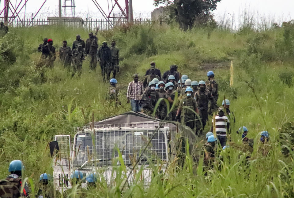 United Nations peacekeepers remove bodies from an area near to where a U.N. convoy was attacked and the Italian ambassador to Congo killed, in Nyiragongo, North Kivu province, Congo Monday, Feb. 22, 2021. The Italian ambassador to Congo Luca Attanasio, an Italian Carabineri police officer and their Congolese driver were killed Monday in an attack on a U.N. convoy in an area that is home to myriad rebel groups, the Foreign Ministry and local people said. (AP Photo/Justin Kabumba)