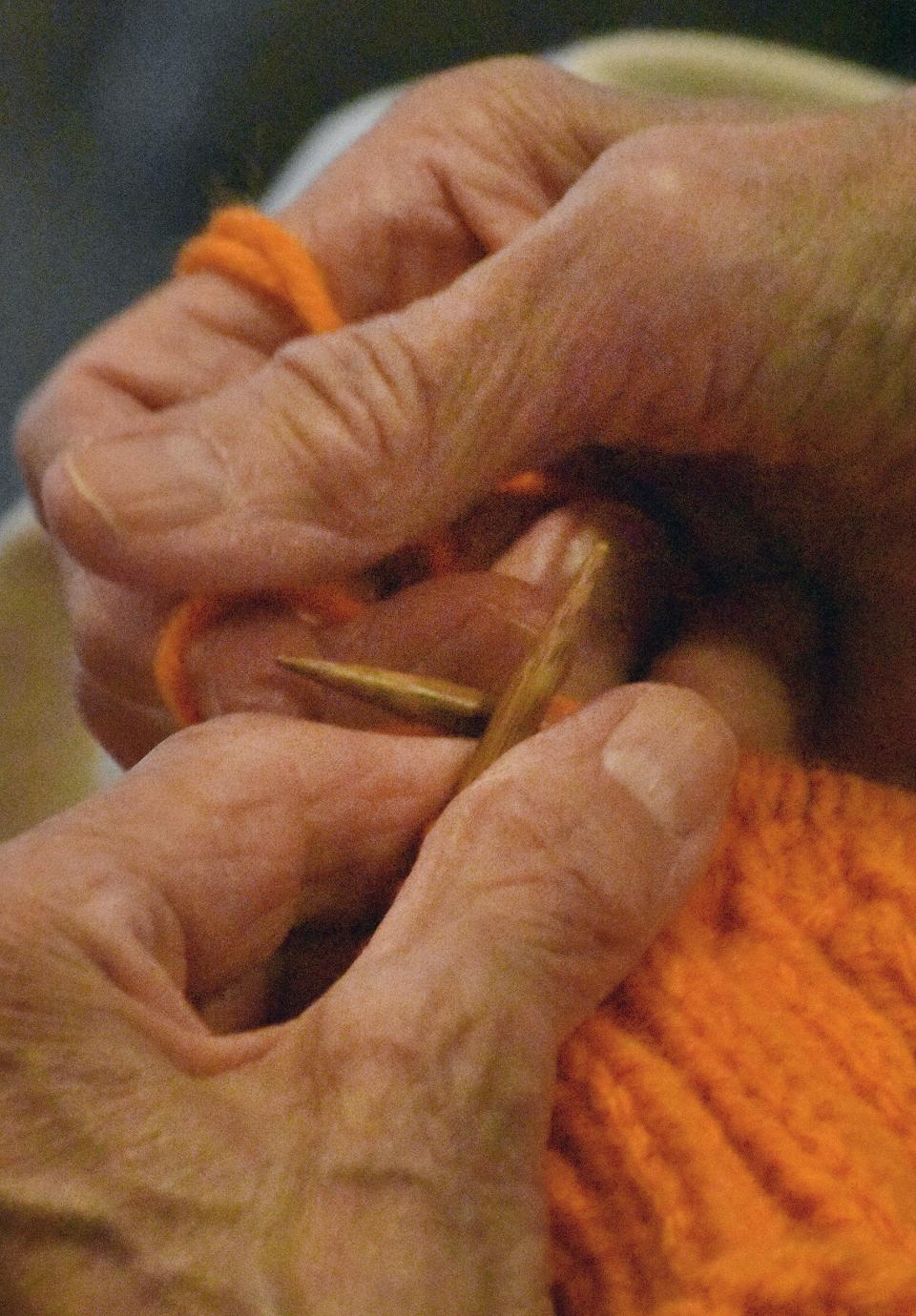 Resident Lorraine Sherry knits an infant hat at Borden Place.