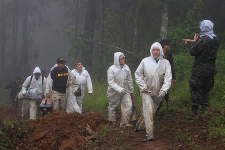 Forensic workers are seen in the area where Hilda Hernandez, the sister of Honduran President Juan Orlando Hernandez, and five others died when the helicopter they were traveling in crashed in San Matias, Honduras, December 17, 2017. REUTERS/ Jorge Cabrera