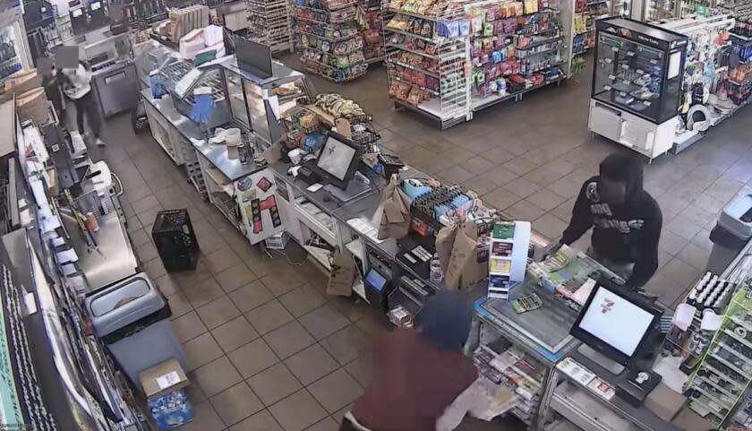 Video screenshot from LAPDHQ Instagram account of suspects taking lottery scratchers at a 7-11.