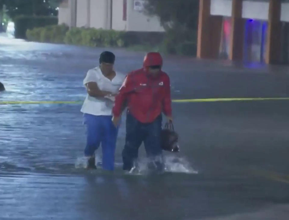 WESH 2 News reporter Tony Atkins saves a nurse from flood waters caused by Hurricane Ian. (NBC News)