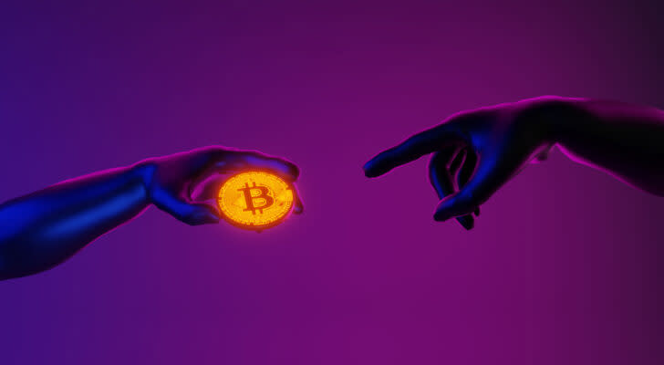 Hands mimicking Michelangelo pose from Sistine Chapel, with one hand holding a Bitcoin (BTC) coin and another hand reaching for the coin against a purple backdrop