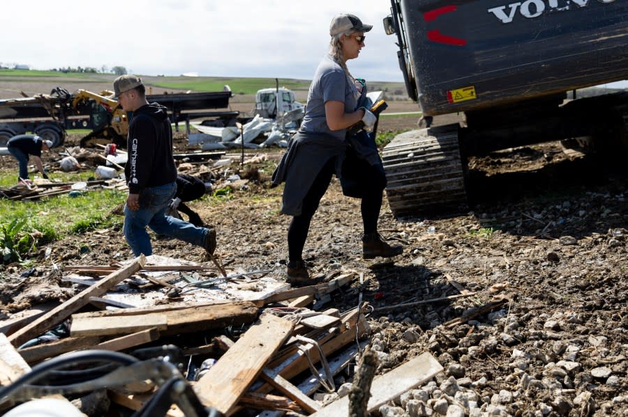 Tory Crozier, 30, cleans up the damage to her family’s property near Minden, Iowa on Saturday, April 27, 2024, after a tornado the previous evening. (Anna Reed/Omaha World-Herald via AP)