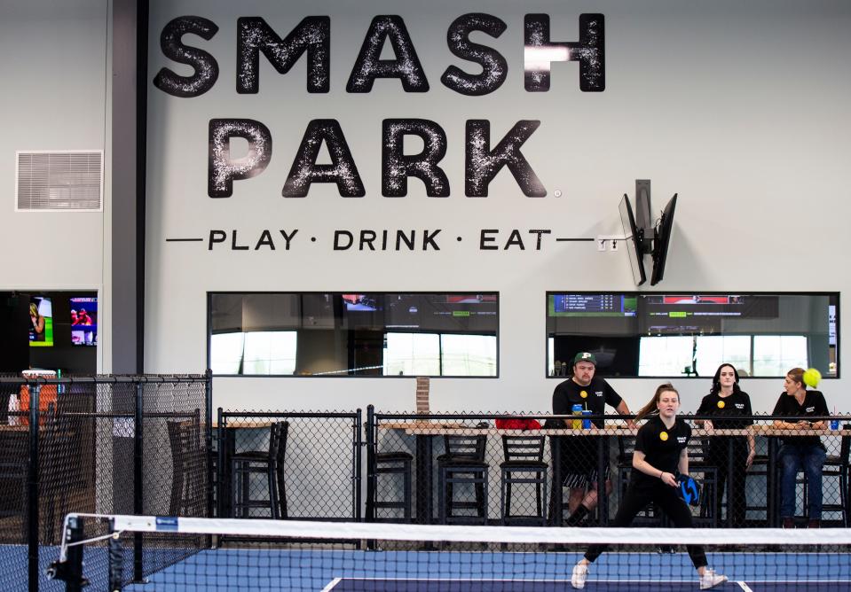 Smash Park cocktail server Hailey Kowzan, bottom right, plays pickleball during a VIP weekend for the first look at Smash Park's new location Friday, May 13, 2022, in Pella. The location opened to the public on May 17.