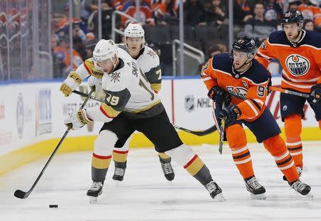 Nov 14, 2017; Edmonton, Alberta, CAN; Vegas Golden Knights forward Reilly Smith (19) skates with the puck as Edmonton Oilers forward Connor McDavid (97) defends during the second period at Rogers Place. Mandatory Credit: Perry Nelson-USA TODAY Sports