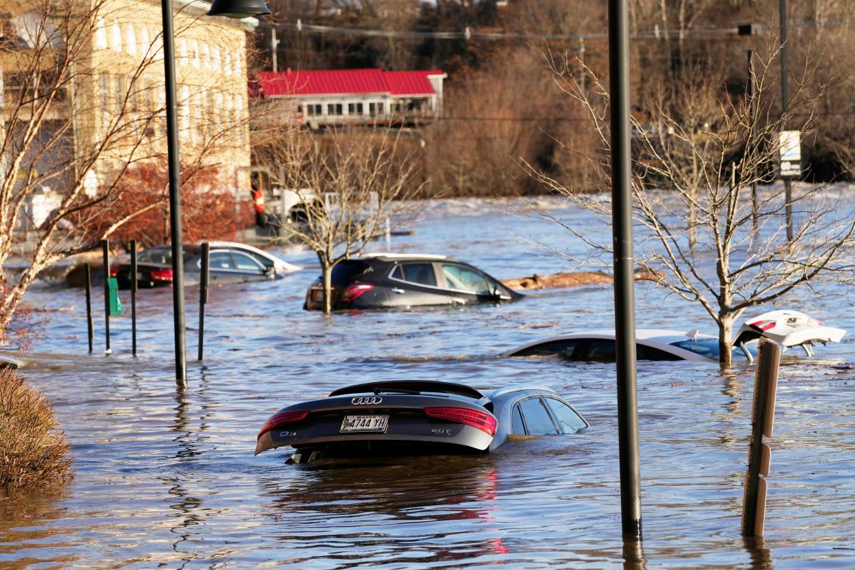 Cars are flooded in a parking lot at the Hathaway Creative Center alongside the Kennebec River, Tuesday, Dec. 19, 2023, in Waterville, Maine. A severe storm on Monday flooded rivers and knocked out power to hundreds of thousands.