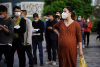 People wearing face masks line up outside Xianning Central Hospital in Xianning