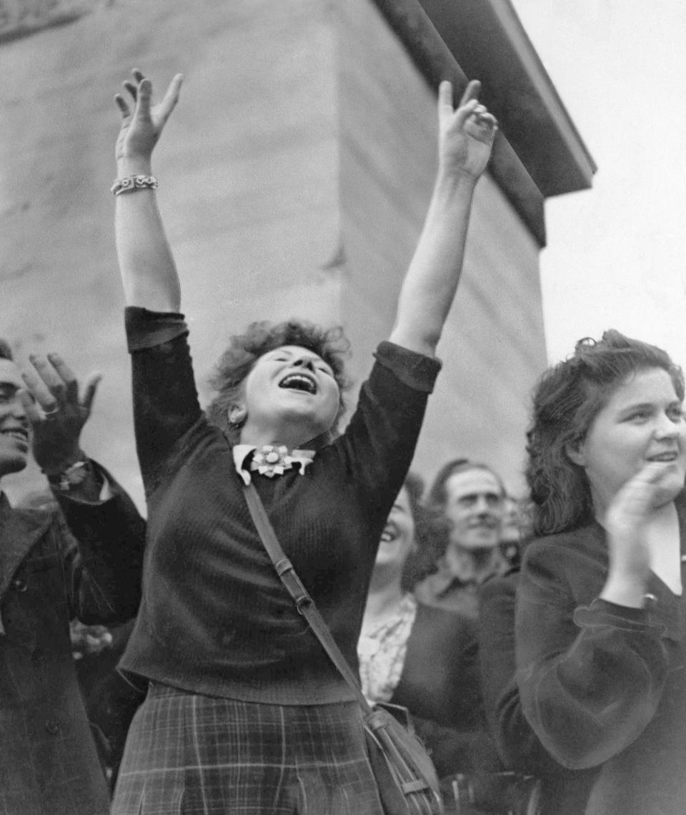 FILE - In this Aug. 25, 1944 file photo, a Parisian girl hold her hands high in the victory sign as American troops pass through Paris, on their way to the front after the French capital was liberated. The fighting for the liberation of Paris took place from August 19 to August 25, 1944. (AP Photo/Richard Boyer, File)