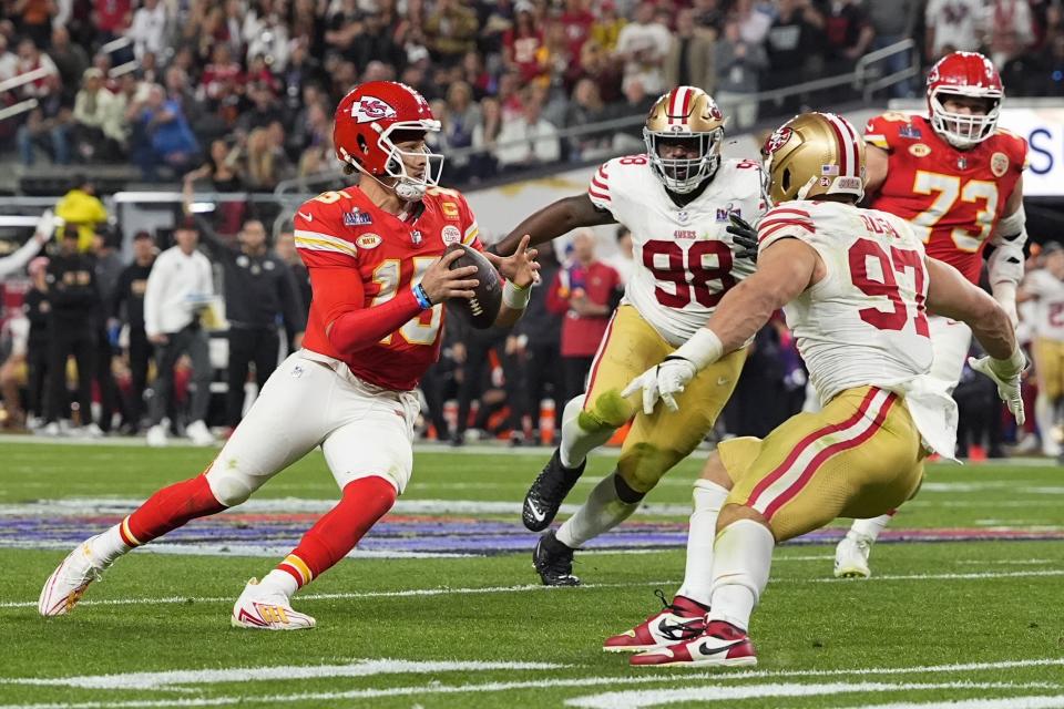 Kansas City Chiefs quarterback Patrick Mahomes (15) scrambles as San Francisco 49ers defensive end Nick Bosa (97) and defensive tackle Javon Hargrave (98) pursue during the second half of the NFL Super Bowl 58 football game Sunday, Feb. 11, 2024, in Las Vegas. (AP Photo/Julio Cortez)