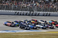 Ross Chastain (1) leads a pack of cars to through the Tai-Oval during a NASCAR Cup Series auto race Sunday, Oct. 2, 2022, in Talladega, Ala. (AP Photo/Butch Dill)