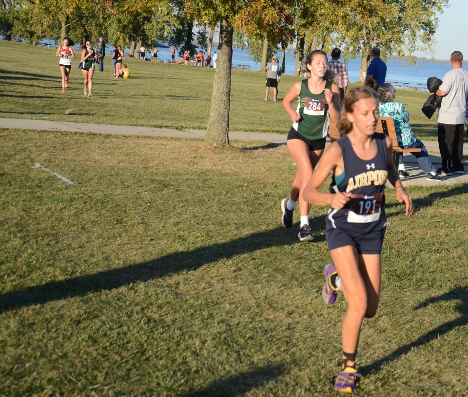Sydney Mason of Airport and St. Mary Catholic Central’s Callyanne Flint run in the Huron League jamboree at Sterling State Park Tuesday.