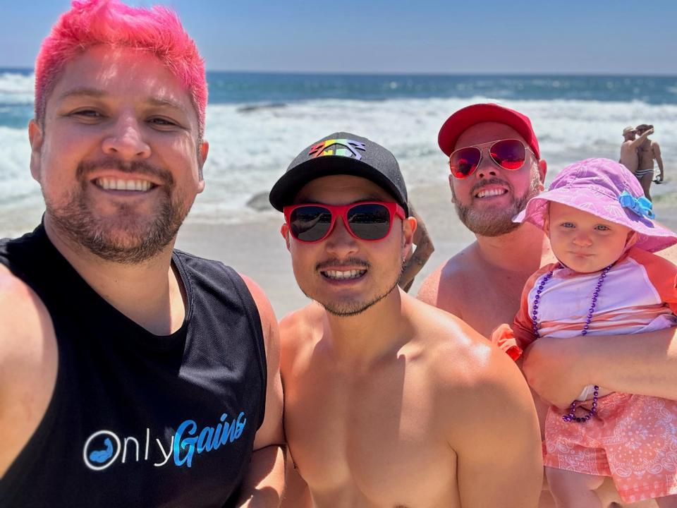 A family beach day with Ben, Benjamin, Mitch, and their daughter Tegan.