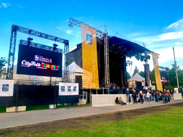 People wait by the stage at a scaled-down Bluesfest taking place at Ottawa's Lansdowne Park on Sept. 25, 2021, during the COVID-19 pandemic. (Nicholas Cleroux/Radio-Canada - image credit)