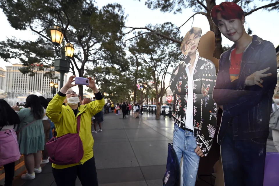 LAS VEGAS, NEVADA - APRIL 07: A BTS fan takes a selfie with cardboard cutouts of band members along the Las Vegas Strip on April 07, 2022 in Las Vegas, Nevada. The K-Pop band kicks off four shows at Allegiant Stadium tomorrow night, which marks their first U.S. concerts since the COVID-19 pandemic shutdown.   (Photo by David Becker/Getty Images)