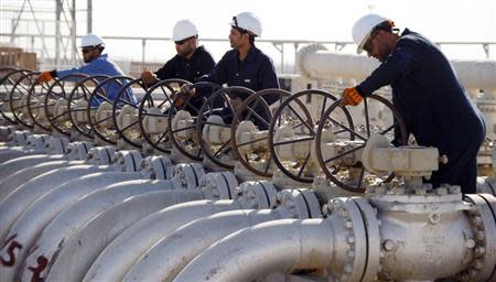 Workers adjust the valves of oil pipes at West Qurna oilfield in Iraq's southern province of Basra November 28, 2010. REUTERS/Atef Hassan