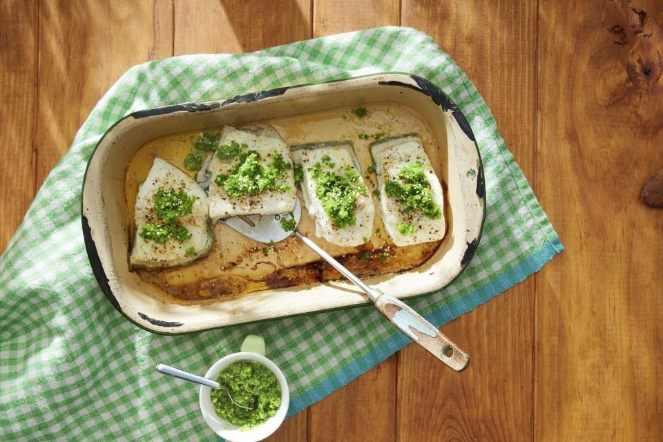 baked halibut with snap pea and toasted sesame gremolata on top and arranged in a white baking dish