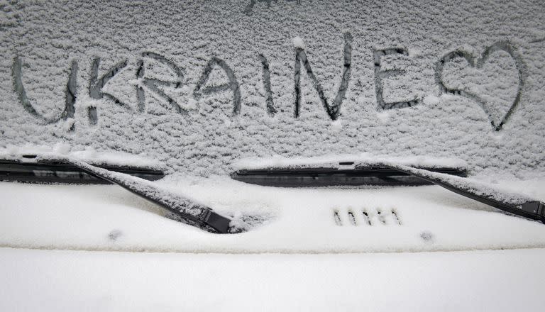 El parabrisas de un auto en Kiev, con la primera nevada de la temporada y un corazón junto al nombre del país
