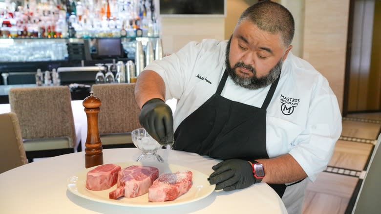 Chef Walter Mayen seasoning steaks