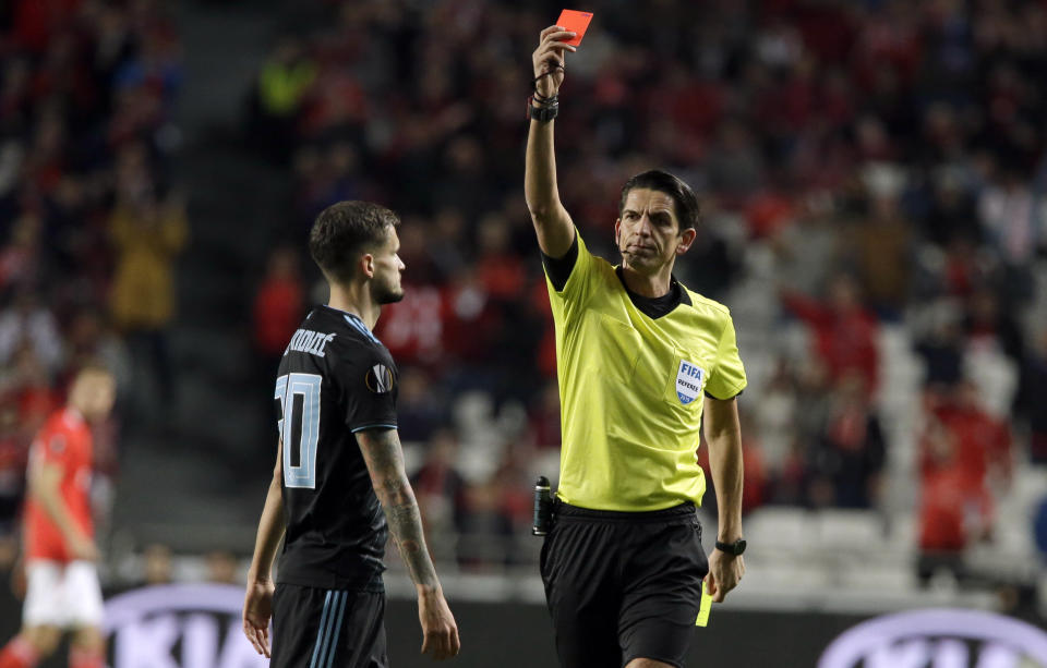 Referee Deniz Aytekin shows a red card to Dinamo Zagreb's Petar Stojanovic during the Europa League round of 16, second leg, soccer match between Benfica and Dinamo Zagreb at the Luz stadium in Lisbon, Thursday, March 14, 2019. (AP Photo/Armando Franca)