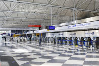 FILE - In this June 25, 2020, file photo, rows of United Airlines check-in counters at O'Hare International Airport in Chicago are unoccupied amid the coronavirus pandemic. About 40,000 workers in the airline industry are facing layoffs on Thursday, Oct. 1, unless Congress comes up with another aid package. With air travel down about 70% from last year, many carriers including United and American say they’ll be forced to cut jobs without additional aid. (AP Photo/Teresa Crawford, File)