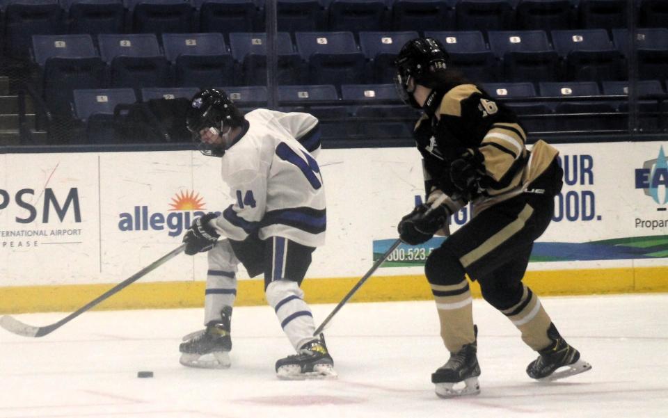 Oyster River's Nicholas Dreher, left, tries to control the puck ahead of Trumbull's Cohen Barton during Thursday night's Heuchling & Swift  Memorial Classic at the Whittemore Center.