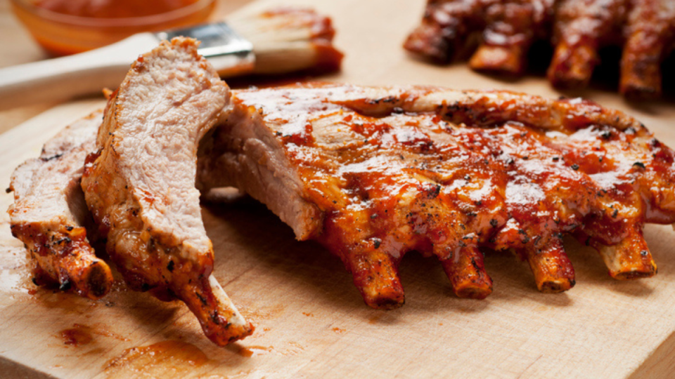 close up of oven-baked baby back ribs glazed in barbecue sauce