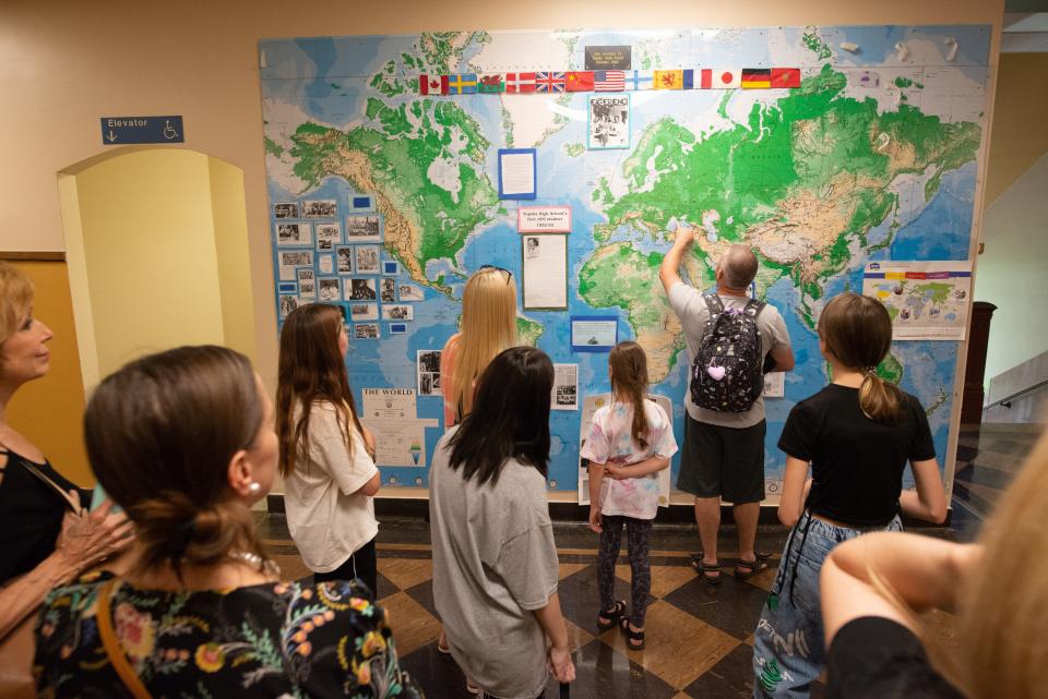 Ukrainian parents of soon-to-be students enrolled at Topeka High School point out their home country on a world map that illustrates where foreign exchange students over the years have come from Tuesday afternoon.