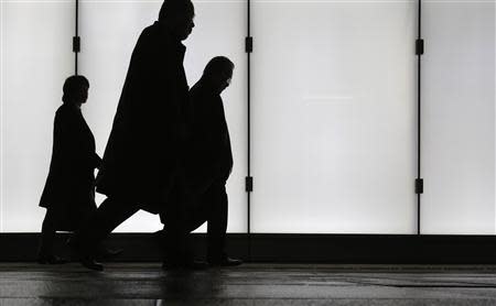 People walk at a business district in Tokyo January 30, 2014. Picture taken January 30, 2014. REUTERS/Yuya Shino