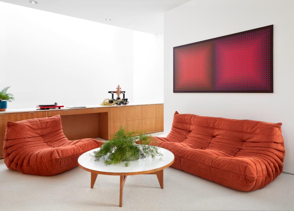 “This is where we hang out at night after our kids to go sleep,” says Kristen of the open-air den area outside the master bedroom. The seating is by Ligne Roset, the painting is by Julian Stanczak, and the sculpture is by Zachary Leener.