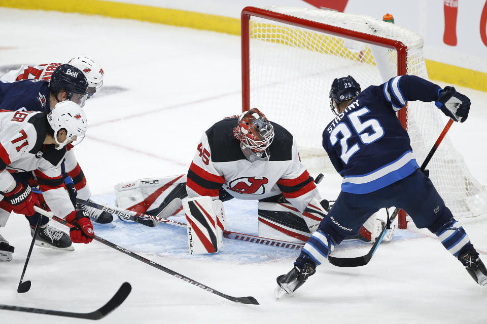 New Jersey Devils goaltender Jonathan Bernier (45) makes a save on Winnipeg Jets' Paul Stastny (25) during the second period of an NHL hockey game Friday, Dec. 3, 2021, in Winnipeg, Manitoba. (John Woods/The Canadian Press via AP)