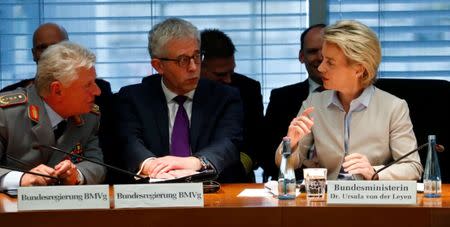 German Defence Minister Ursula von der Leyen (R) talks to State Secretary Gerd Hoofe (C) and General Inspector of the German Armed Forces, Volker Wieker, as she faces the defence commission of the lower house of parliament Bundestag in Berlin, Germany May 10, 2017. REUTERS/Fabrizio Bensch