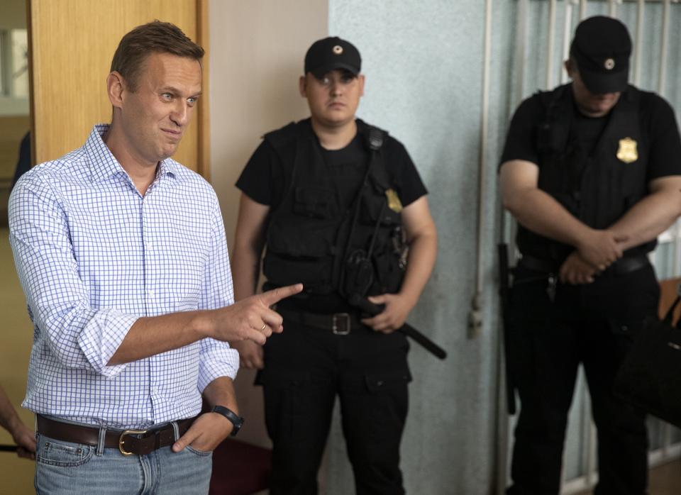 Russian opposition activist Alexei Navalny, left, gestures in a court before a hearing in Moscow, Russia, Monday, July 1, 2019. A Moscow court jailed Russian opposition leader Alexei Navalny for 10 days on Monday after finding him guilty of breaking the law when he took part in a street demonstration last month. (AP Photo/Pavel Golovkin)