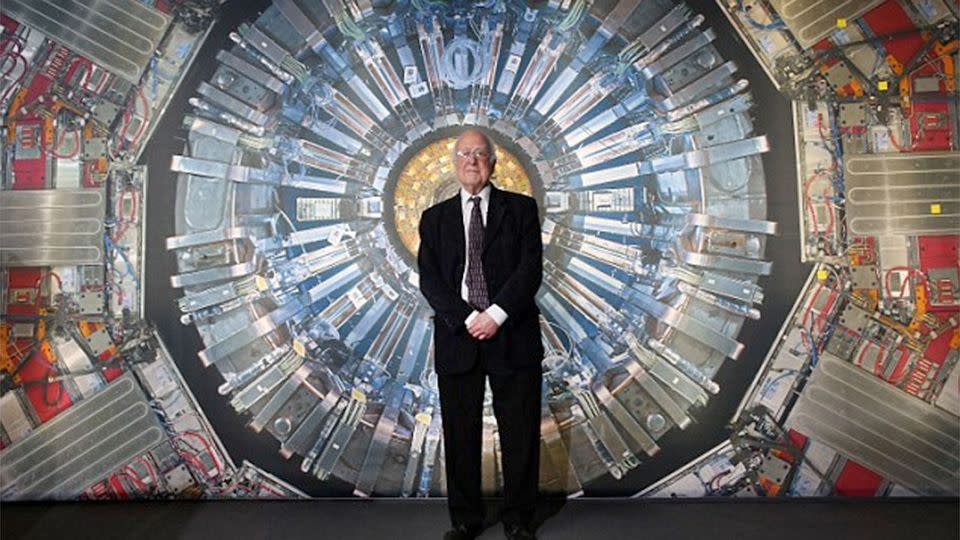 Peter Higgs stands in front of a photograph of the Large Hadron Collider at the Science Museum's 'Collider' exhibition in London. Photo: Getty Images