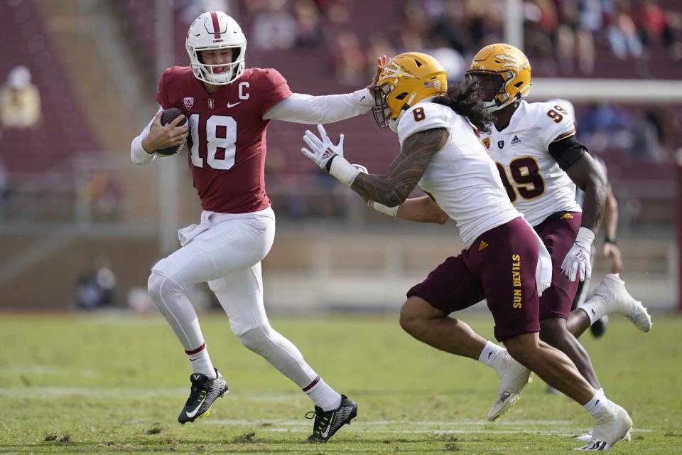 Stanford quarterback Tanner McKee runs against Arizona State linebacker Merlin Robertson.