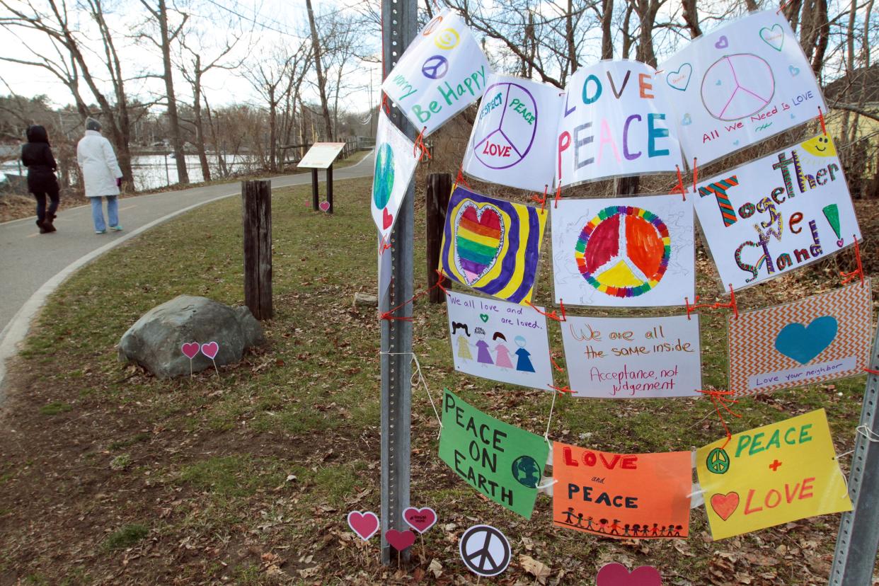 Signs calling for peace, love and acceptance are placed near the East Bay Bike Path in Barrington in 2017 after a sign on the path and near a synagogue was defaced with a swastika.