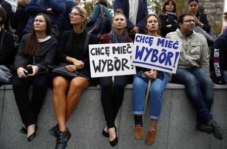 Women hold placards as they take part in a "Black Protest" in front of the Parliament in Warsaw, Poland. The placards read: "I want to have a choice!" REUTERS/Kacper Pempel