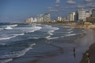 A woman walks on the Tel Aviv's Mediterranean Sea beachfront, Israel, Thursday, Dec. 2, 2021. Residents of Israel's seaside metropolis Tel Aviv have for years complained of how expensive it is, with living costs taking a chunk out of their paychecks. A report released Wednesday, Dec. 1, 2021, by the Economist Intelligence Unit, a research group linked to the Economist magazine, said Tel Aviv has emerged as the most expensive city to live in. (AP Photo/Oded Balilty)