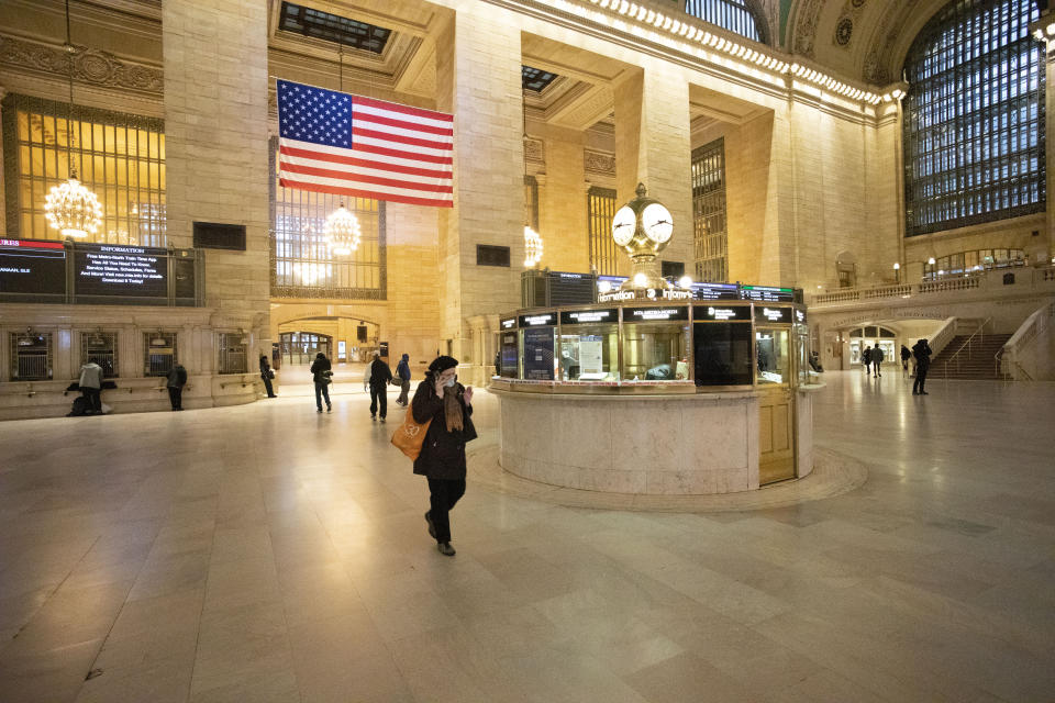 Commuters pass through Grand Central Terminal during the morning rush hour, Monday, March 23, 2020, in New York. Gov. Andrew Cuomo has ordered most New Yorkers to stay home from work to slow the coronavirus pandemic. (AP Photo/Mark Lennihan)